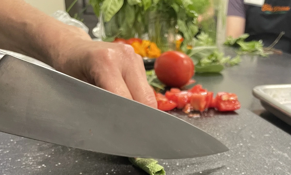 Someone cutting fresh herbs with a knife