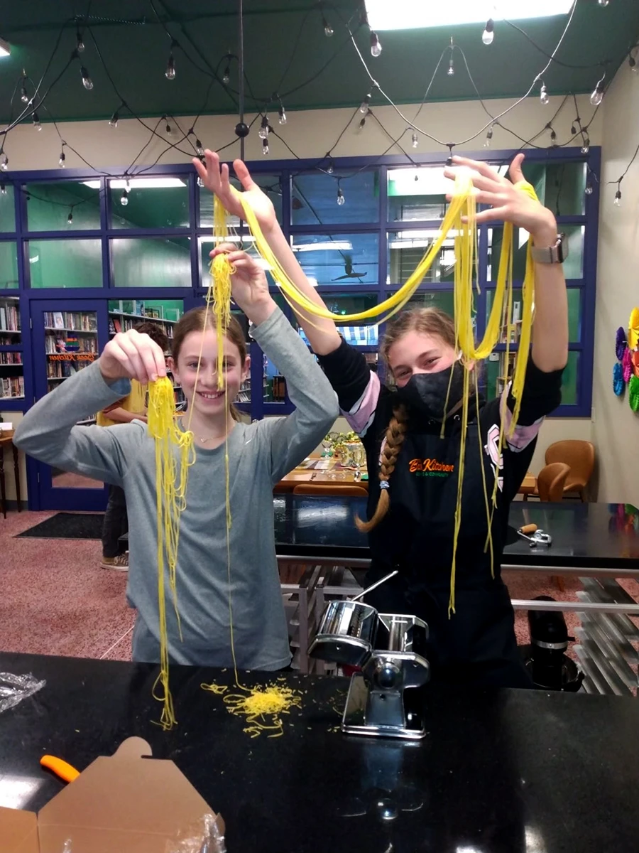 Kids holding up pasta