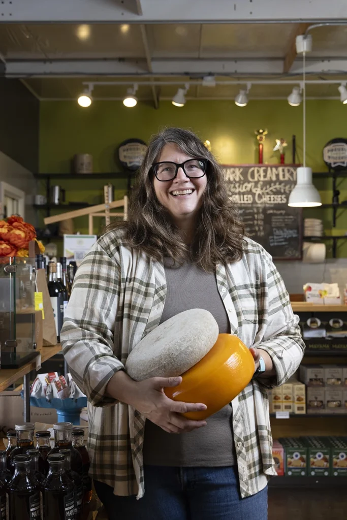 Cheesemaker holding rounds of cheese